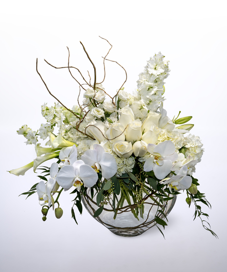 white hydrangea, delphinium, calla lilies, roses and phalaenopsis orchids accented with seeded eucalyptus in a clear vase