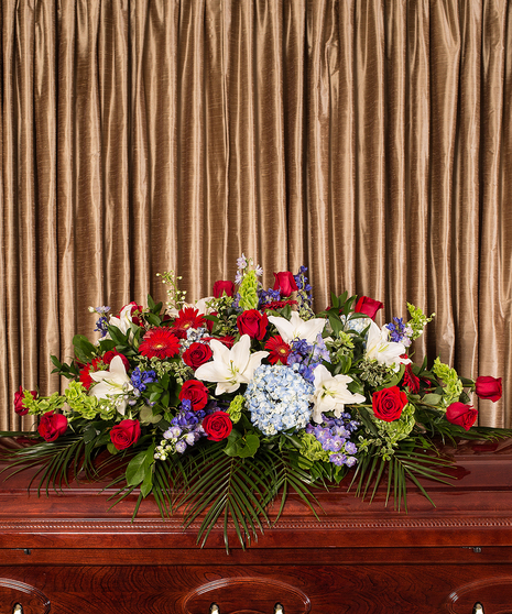 patriotic casket cover in red, white, and blue flowers