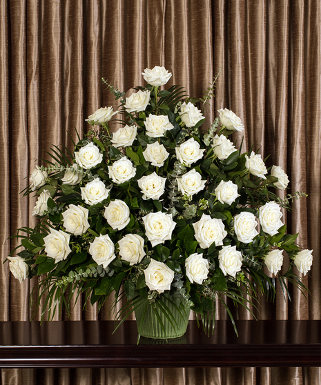 All white roses in front-facing funeral urn